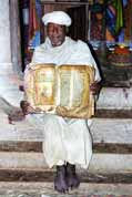 Priest shows old Bible made from goat skin. North, Ethiopia.