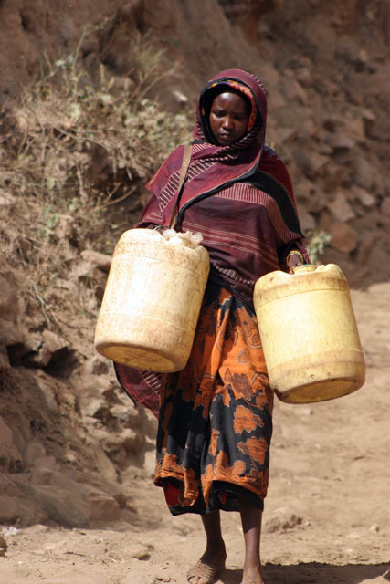 People are going for water, which is retrieving by men-chain from 20m deep wellp, Singing well in Dublock. South,  Ethiopia.